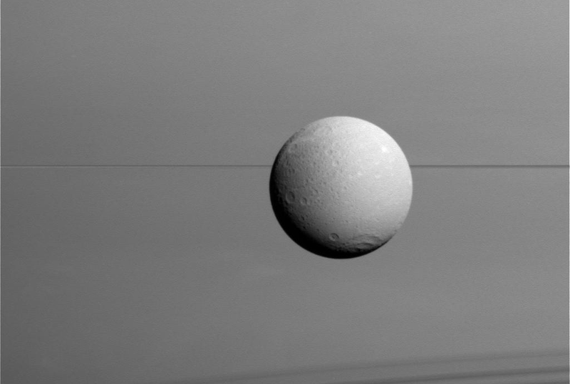 Dione against a backdrop of Saturn’s rings. Image: NASA/JPL-Caltech/Space Science Institute